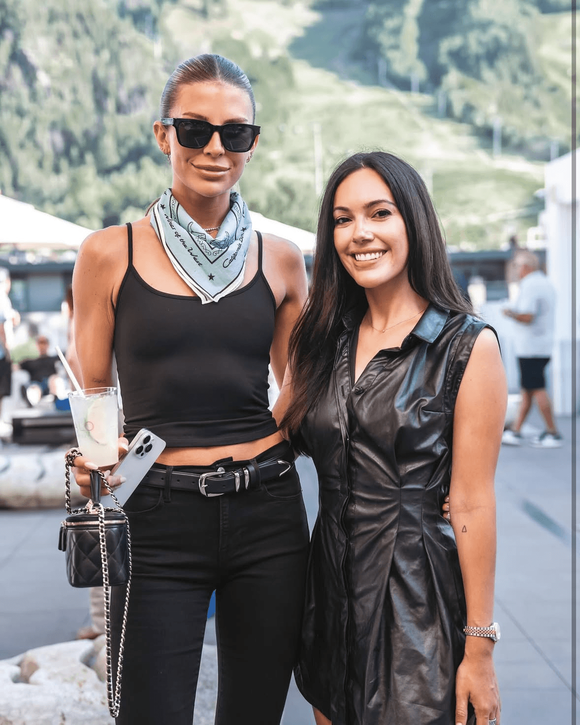 Two women wearing light blue custom bandanas at an outdoor event
