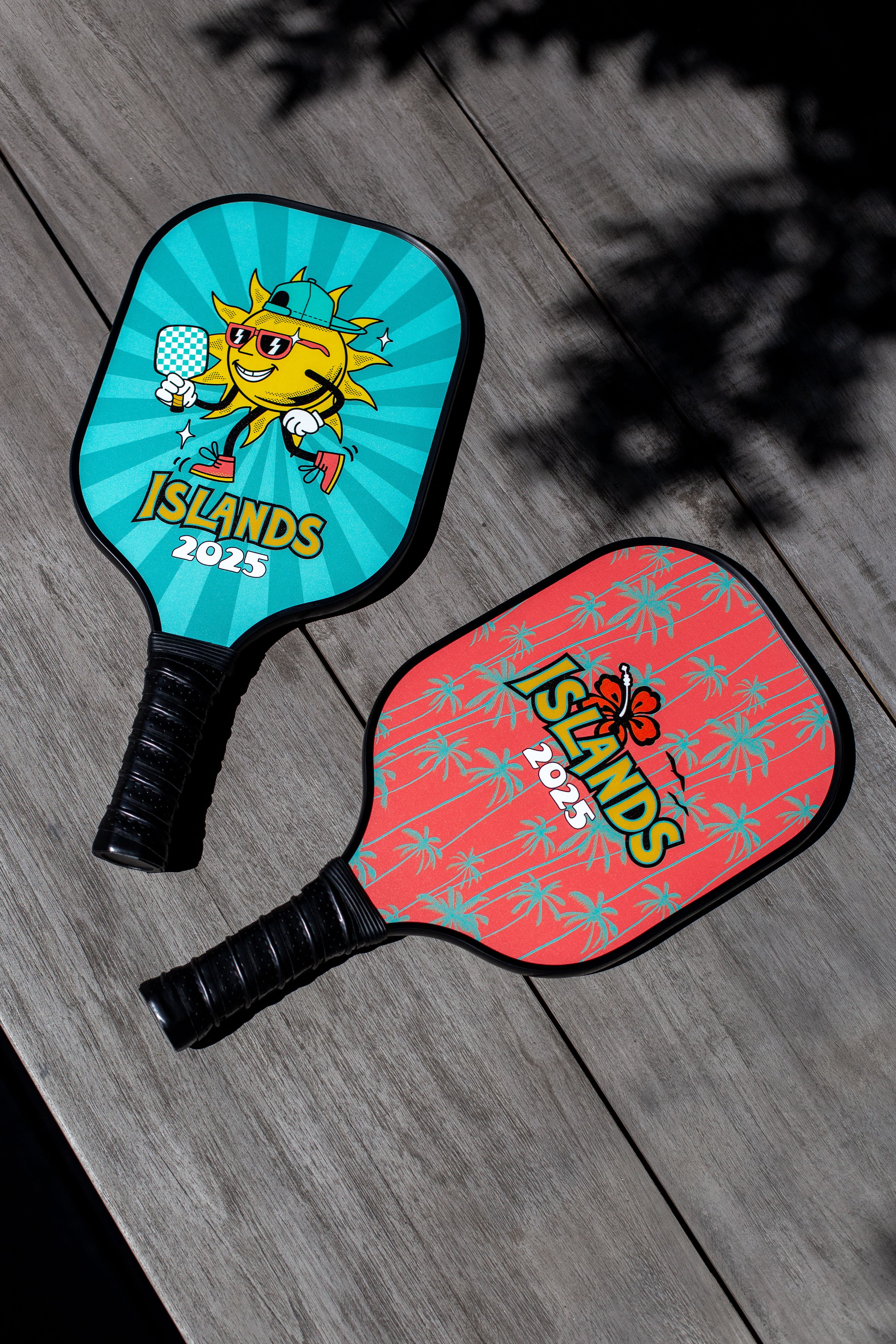 Two custom pickleball paddles with bright Islands 2025 graphics
