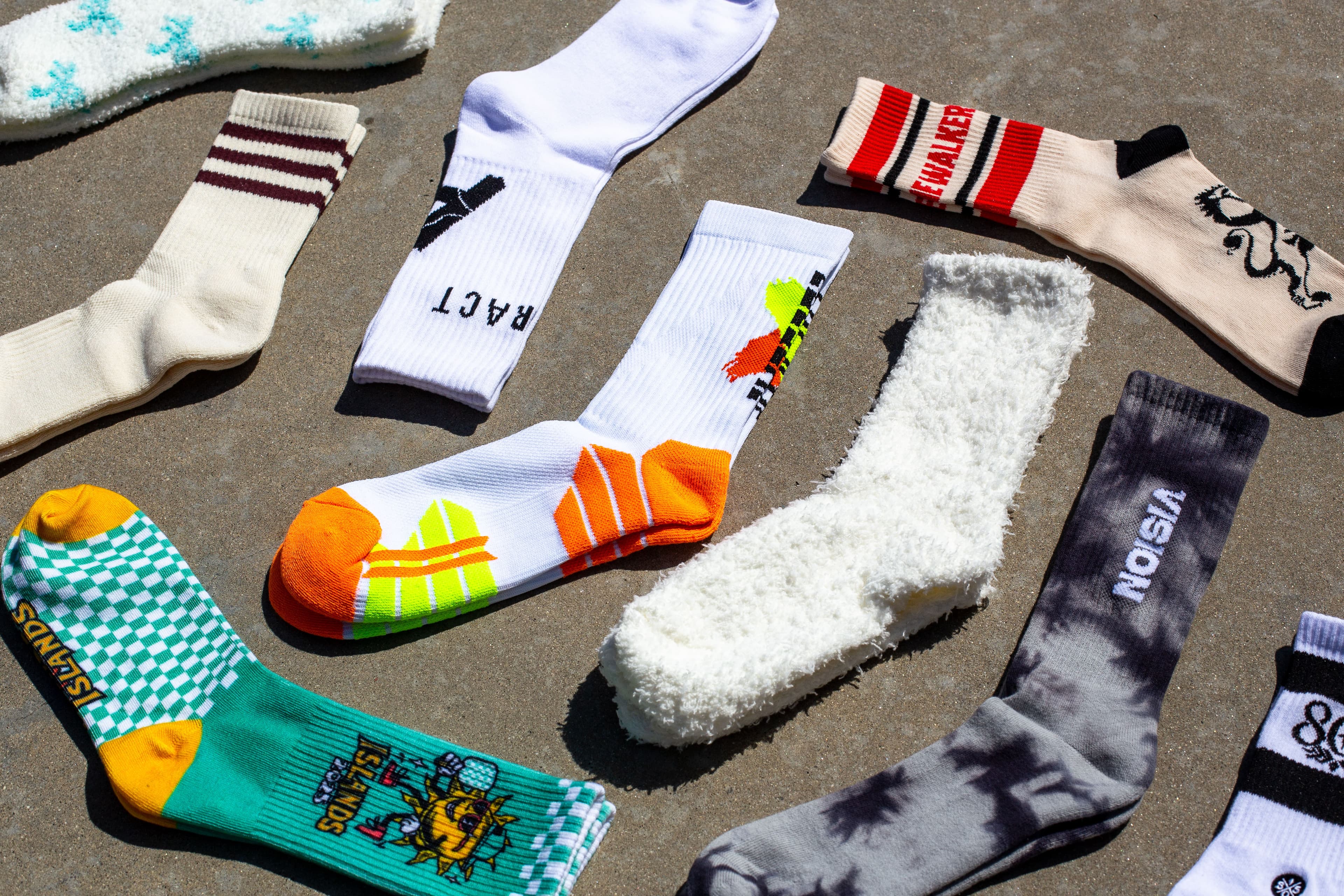 Custom socks styled in a sand flatlay to show a more lifestyle-driven product direction