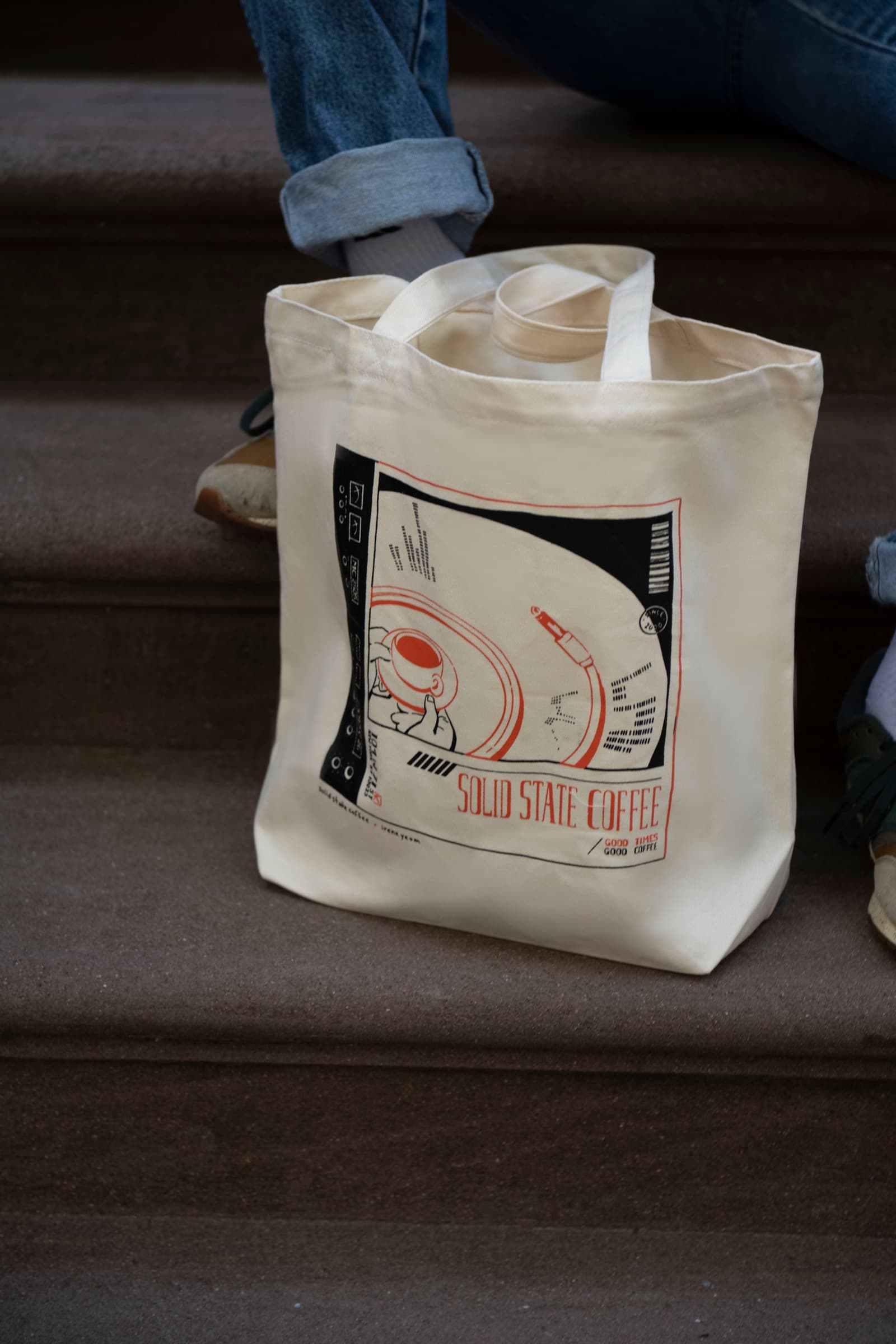 Solid State Coffee tote bag resting on brown outdoor steps
