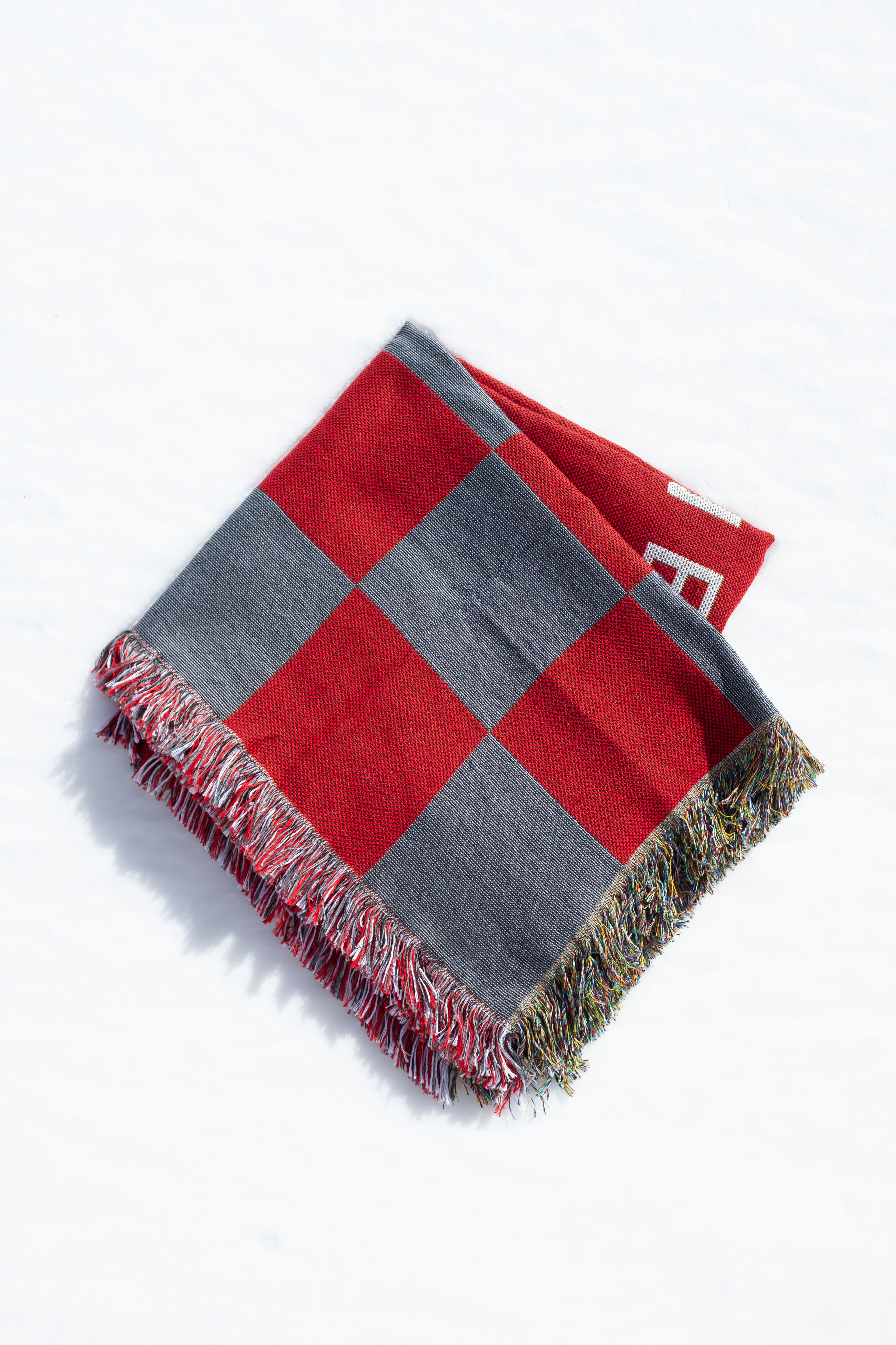 Folded Stanford Medicine woven blanket photographed in the snow