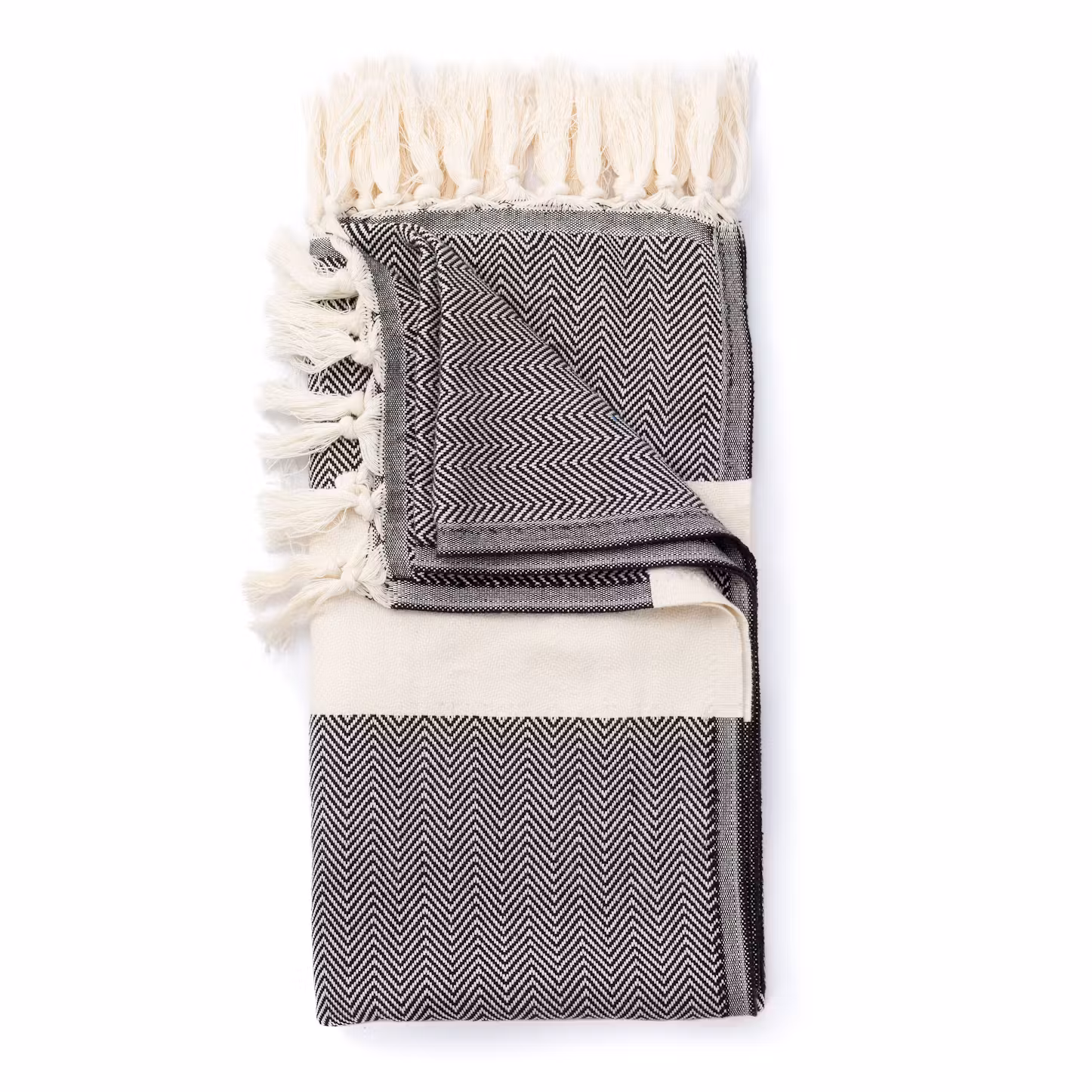 Folded black and cream herringbone Turkish towel with fringe detail on a white background