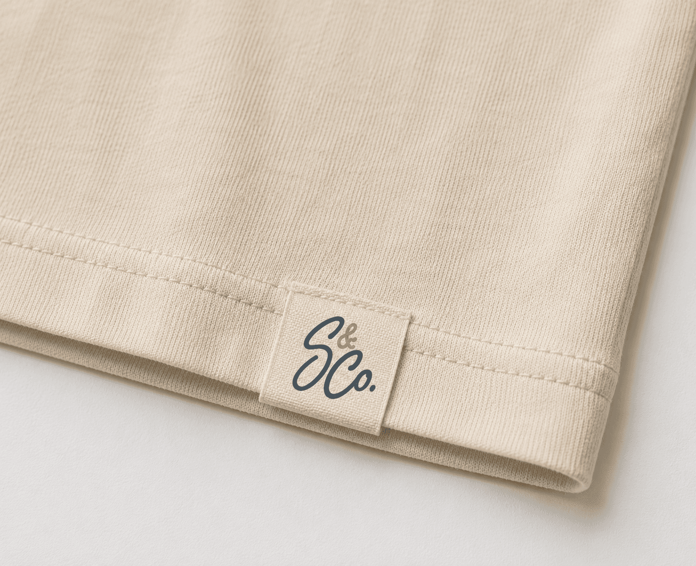Sully & Co hem label sewn into the bottom edge of a cream tee