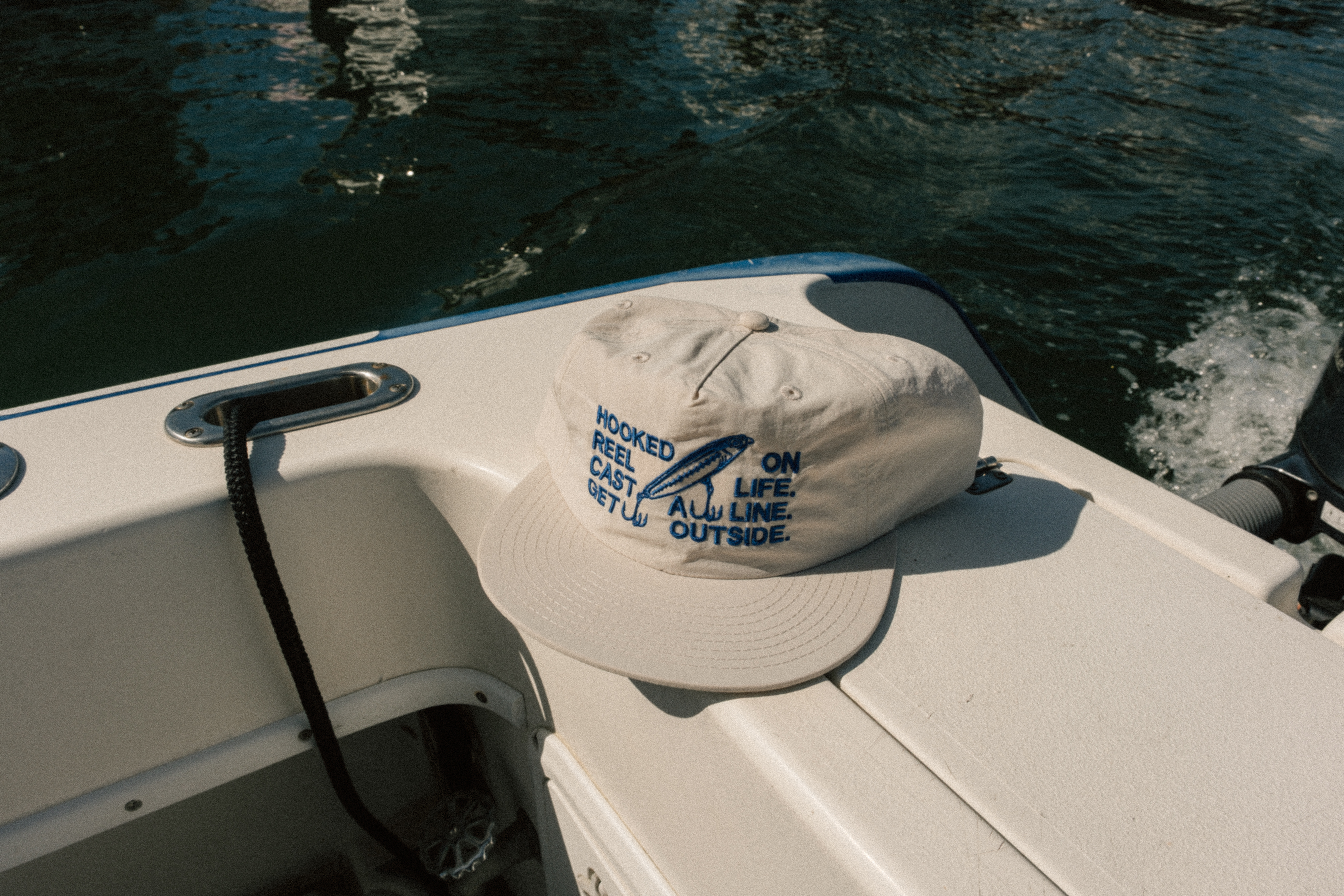 Custom headwear photographed in a coastal boat setting